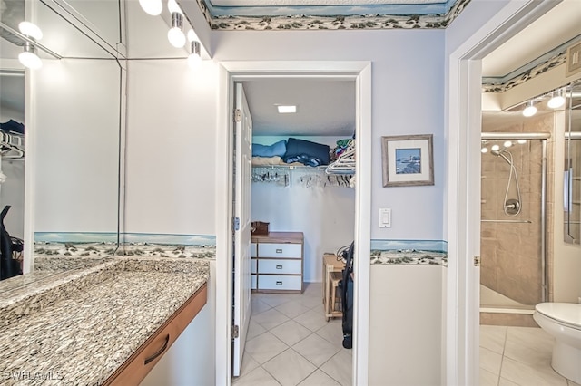 bathroom with tile patterned flooring, vanity, and a shower with shower door