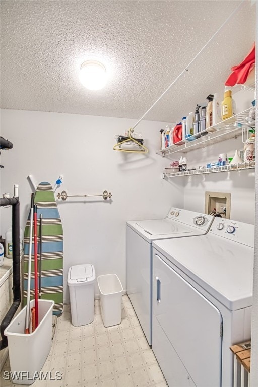 laundry area with a textured ceiling and washer and clothes dryer