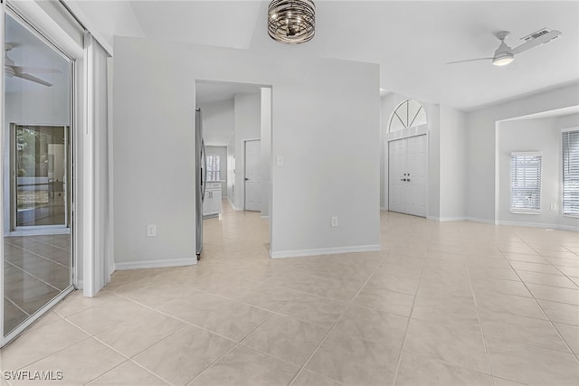 tiled empty room featuring ceiling fan