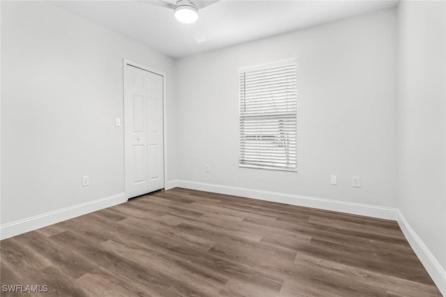 empty room with dark hardwood / wood-style floors and ceiling fan