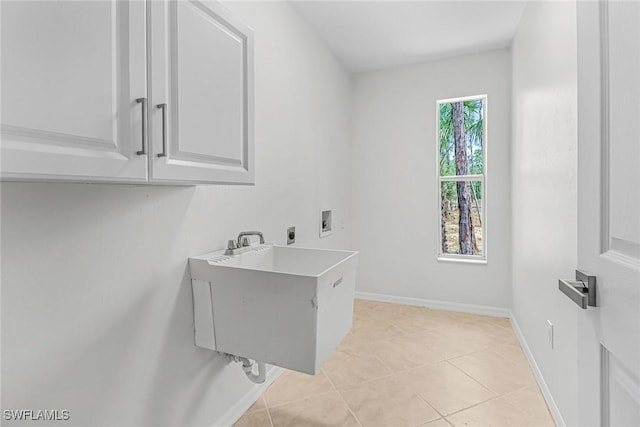 washroom with sink, light tile patterned floors, hookup for a washing machine, cabinets, and hookup for an electric dryer