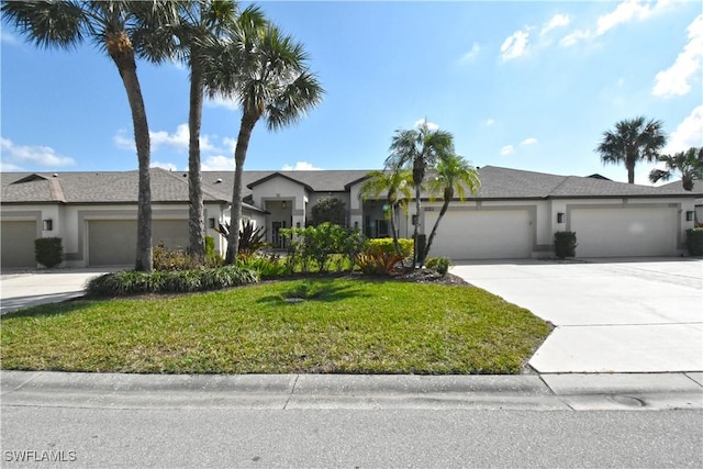 view of front of house featuring an attached garage, concrete driveway, a front lawn, and stucco siding