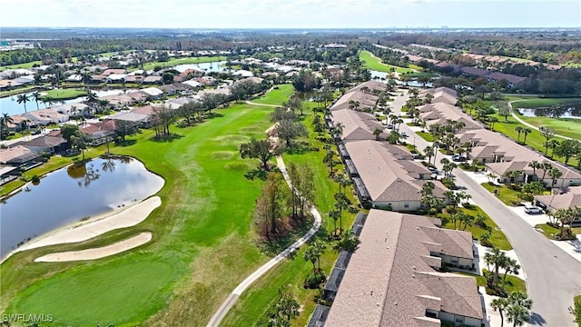 aerial view with golf course view, a water view, and a residential view