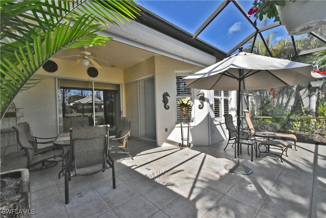 view of patio with outdoor dining space, a lanai, and a ceiling fan
