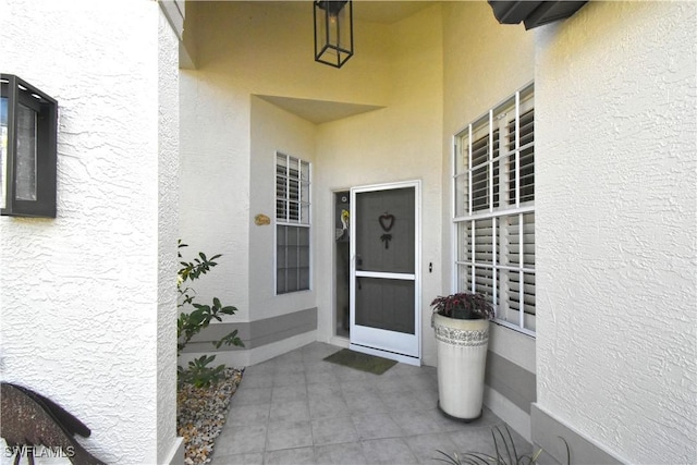 entrance to property with a patio and stucco siding
