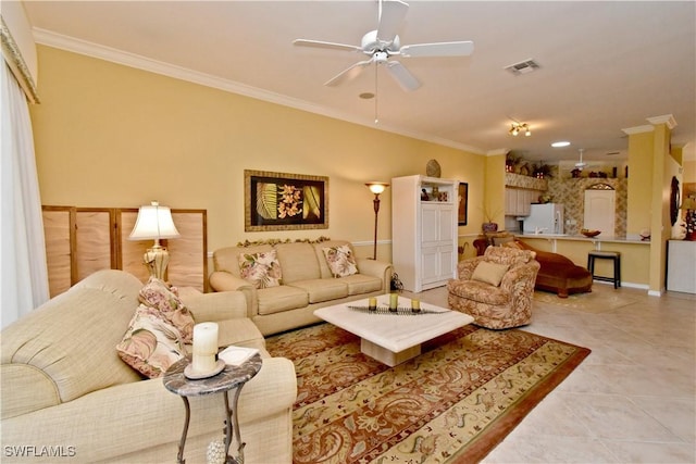 living room featuring crown molding, light tile patterned flooring, visible vents, and ceiling fan