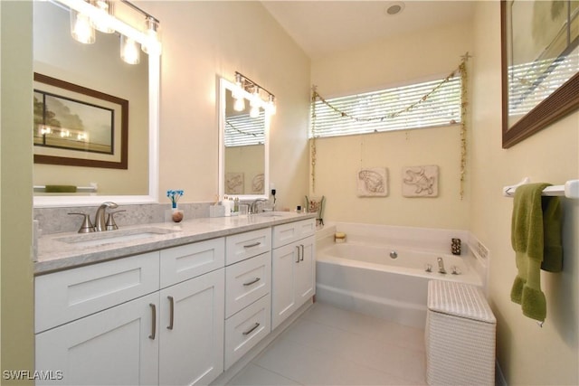 bathroom with a garden tub, double vanity, a sink, and tile patterned floors