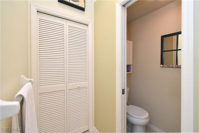 bathroom featuring baseboards and toilet
