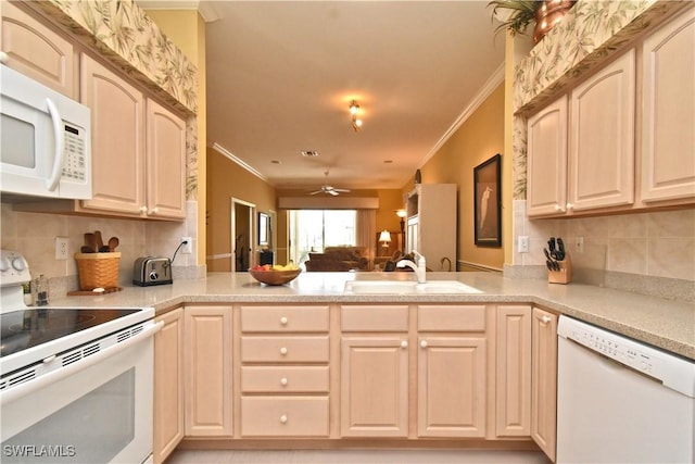 kitchen featuring a sink, tasteful backsplash, a peninsula, white appliances, and ornamental molding