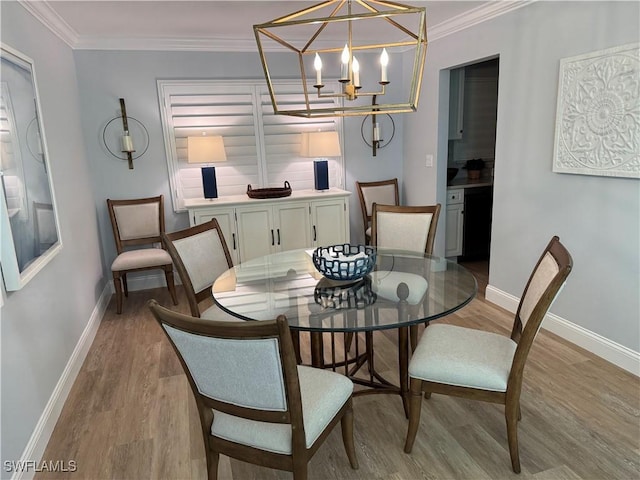 dining room with crown molding, light hardwood / wood-style floors, and a chandelier