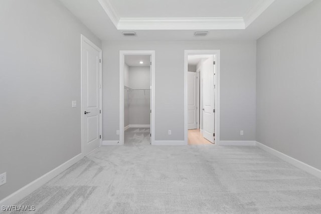 26930 Lark Ct, Punta Gorda, FL 33955 - unfurnished bedroom with ornamental molding, a tray ceiling, a walk in closet, carpet floors, and a closet