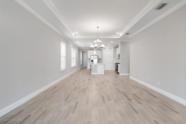 26930 Lark Ct, Punta Gorda, FL 33955 - unfurnished living room featuring a chandelier, light wood-style flooring, a tray ceiling, baseboards, and recessed lighting