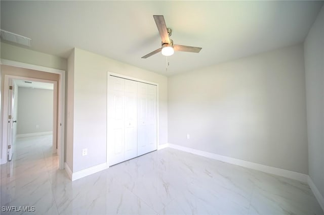 unfurnished bedroom with ceiling fan and a closet