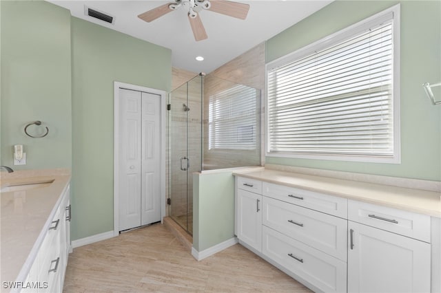 bathroom featuring vanity, ceiling fan, and a shower with shower door