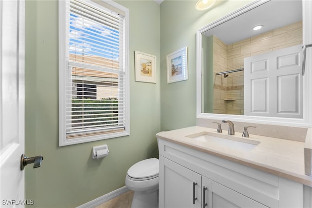 bathroom featuring vanity, toilet, and a tile shower