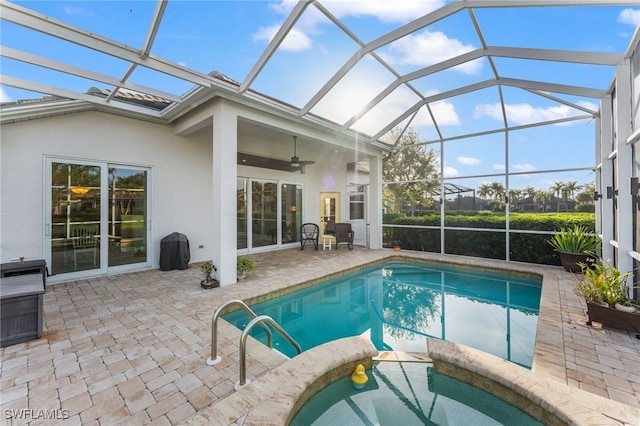 view of pool with a patio, ceiling fan, and glass enclosure