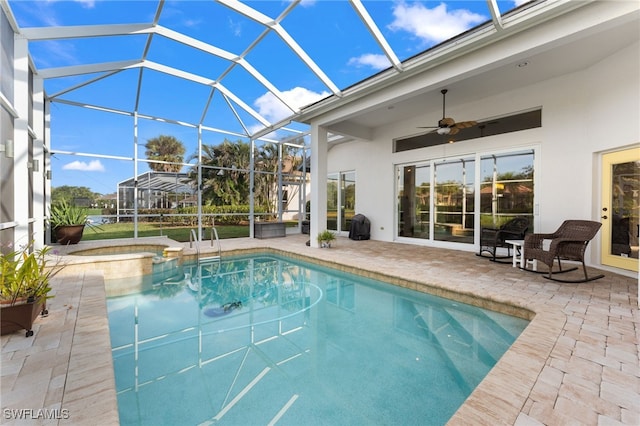 view of swimming pool with an in ground hot tub, ceiling fan, a patio, and glass enclosure