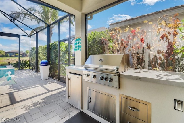 view of patio / terrace featuring an outdoor kitchen, a grill, and a lanai