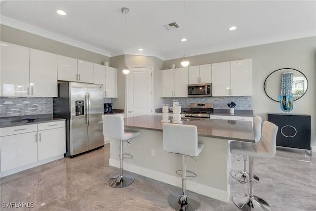 kitchen with stainless steel appliances, an island with sink, and white cabinets