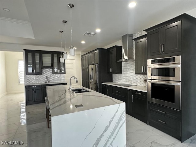 kitchen featuring sink, pendant lighting, stainless steel appliances, a large island, and wall chimney range hood