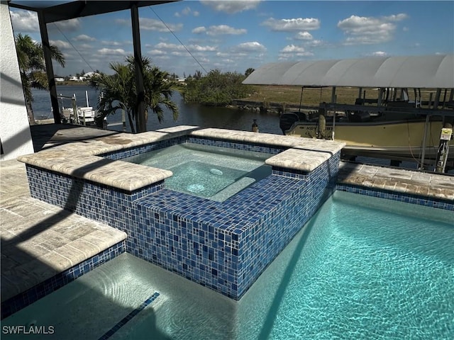 view of pool with an in ground hot tub and a water view