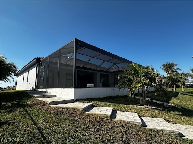 view of property exterior with a yard and glass enclosure