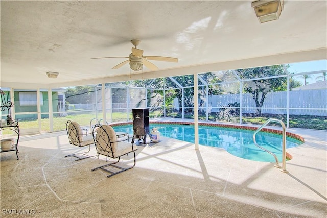 view of pool featuring a patio area, ceiling fan, and glass enclosure