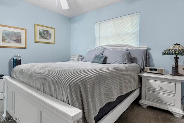 bedroom with ceiling fan and dark colored carpet