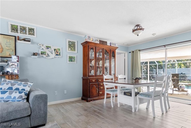 dining area featuring light hardwood / wood-style flooring and ornamental molding