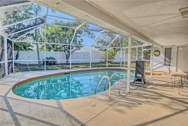 view of swimming pool featuring a patio and glass enclosure