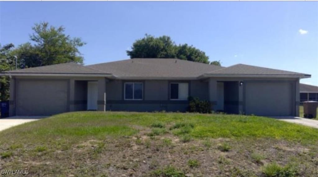 ranch-style house featuring a garage and a front lawn