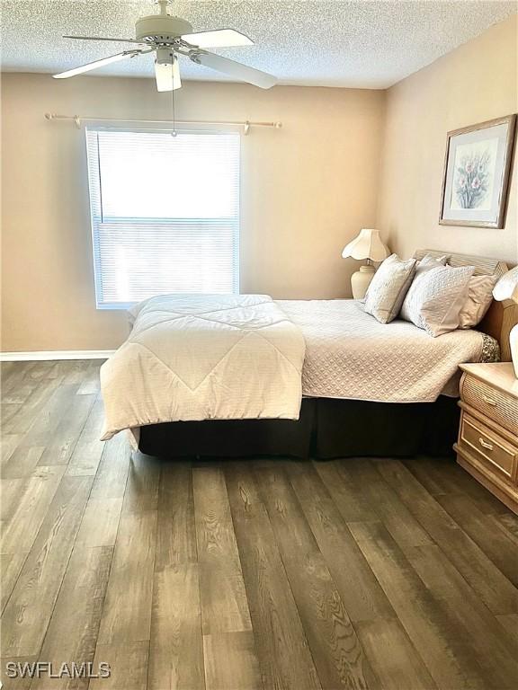 bedroom featuring hardwood / wood-style floors, a textured ceiling, and ceiling fan