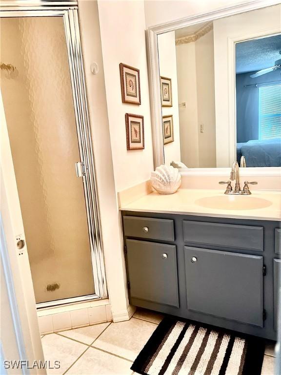 bathroom featuring tile patterned floors, vanity, and a shower with shower door