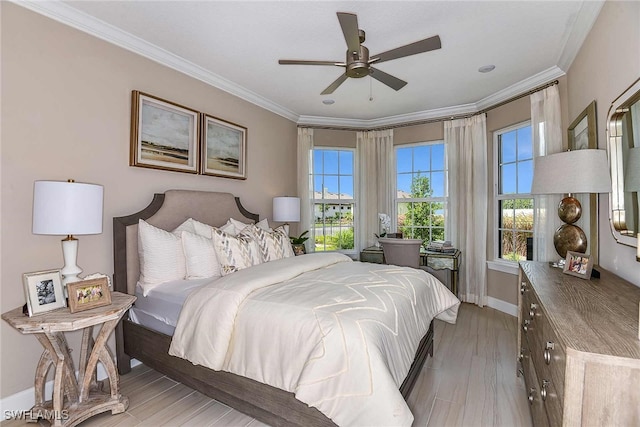 bedroom featuring light wood-style flooring, baseboards, ceiling fan, and crown molding