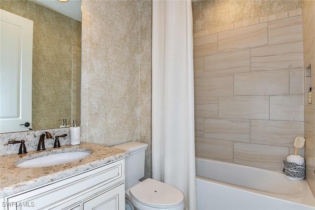 full bathroom featuring toilet, shower / bath combo with shower curtain, and vanity