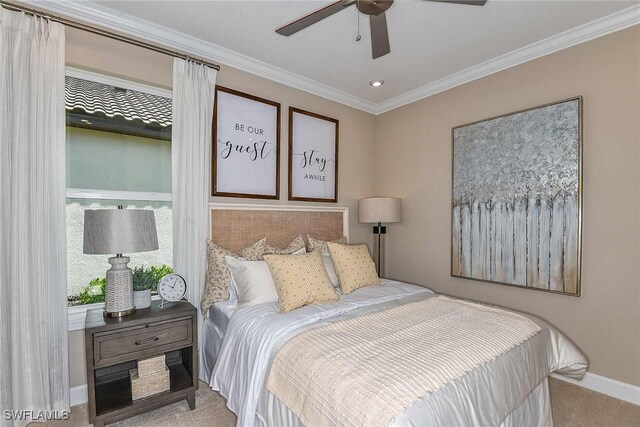 bedroom featuring baseboards, ornamental molding, a ceiling fan, and light colored carpet