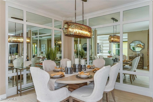 dining area featuring a wealth of natural light, light wood-style flooring, a chandelier, and crown molding