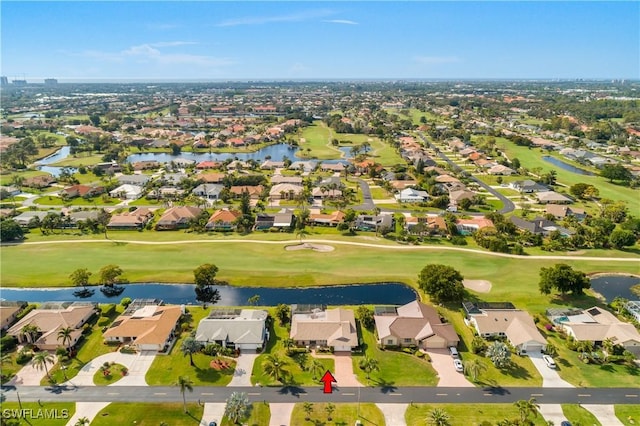 drone / aerial view featuring view of golf course, a water view, and a residential view