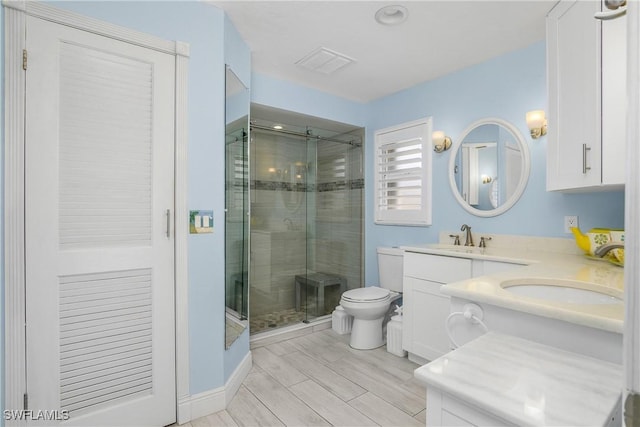 bathroom featuring toilet, a stall shower, and a sink