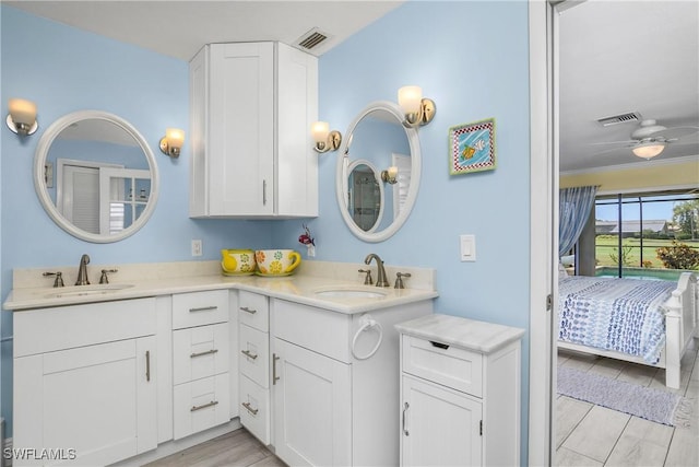 bathroom with visible vents, a sink, and double vanity