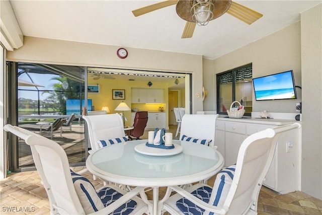 dining space featuring stone tile floors and ceiling fan