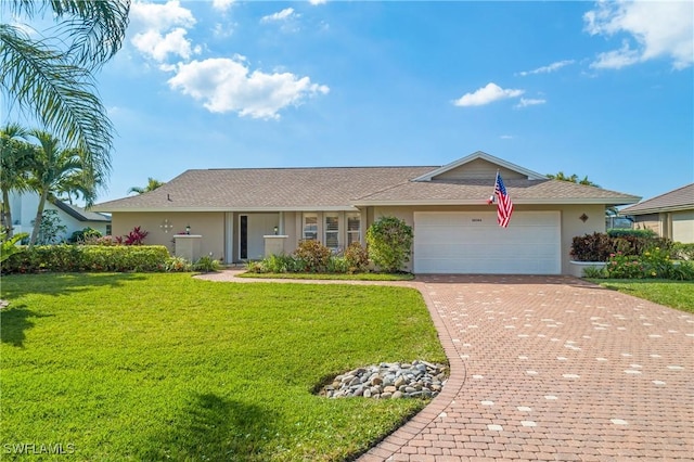 single story home with a garage, a front lawn, decorative driveway, and stucco siding