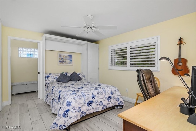 bedroom with wood finish floors, a ceiling fan, and baseboards