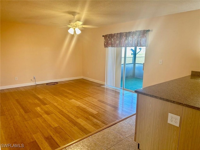 spare room with a textured ceiling, light hardwood / wood-style floors, and ceiling fan