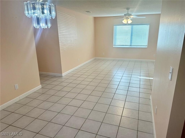 spare room with ceiling fan with notable chandelier and light tile patterned floors