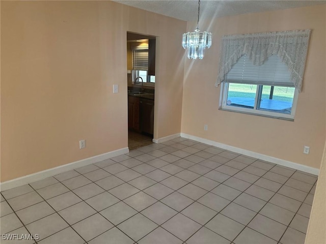 unfurnished room with sink and an inviting chandelier