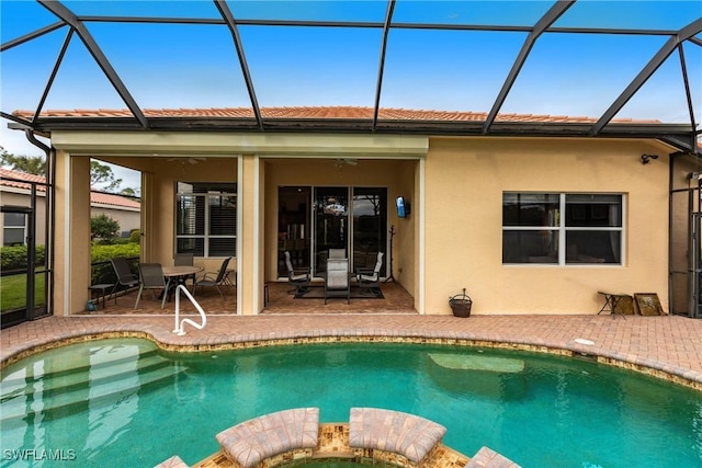 rear view of property with a patio, ceiling fan, and glass enclosure