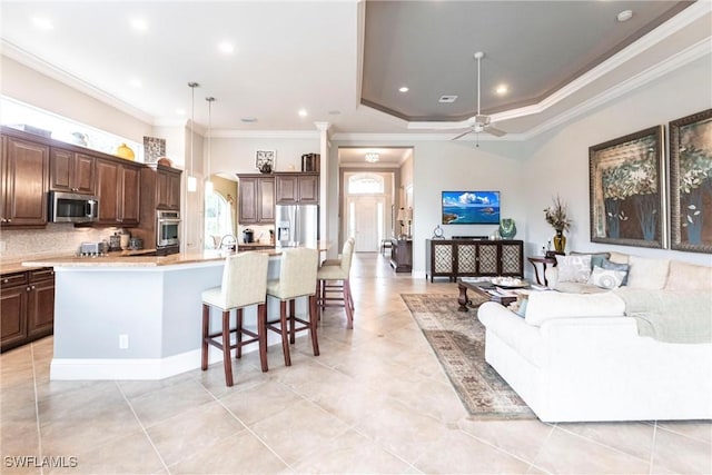 kitchen with hanging light fixtures, an island with sink, appliances with stainless steel finishes, and a kitchen breakfast bar