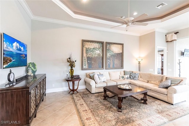 living room with crown molding, light tile patterned floors, a tray ceiling, and ceiling fan