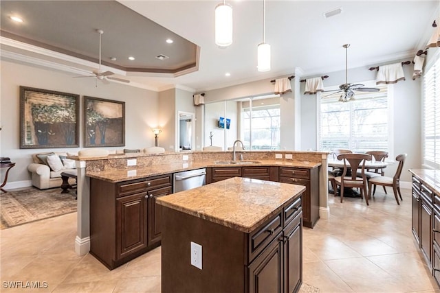 kitchen with a spacious island, sink, decorative light fixtures, dishwasher, and ceiling fan